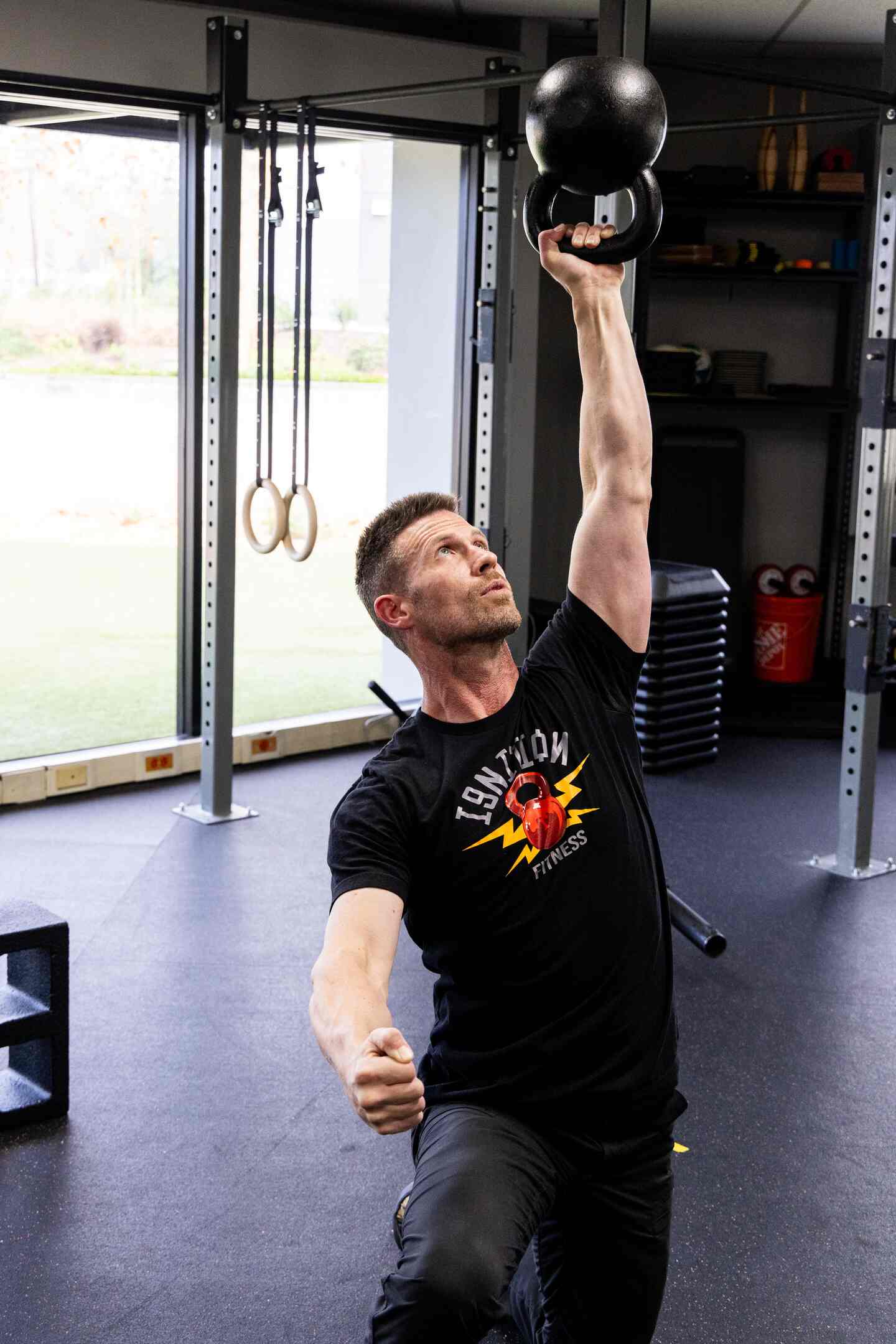 Coach Mike performing a kettlebell overhead press at Ignition Fitness