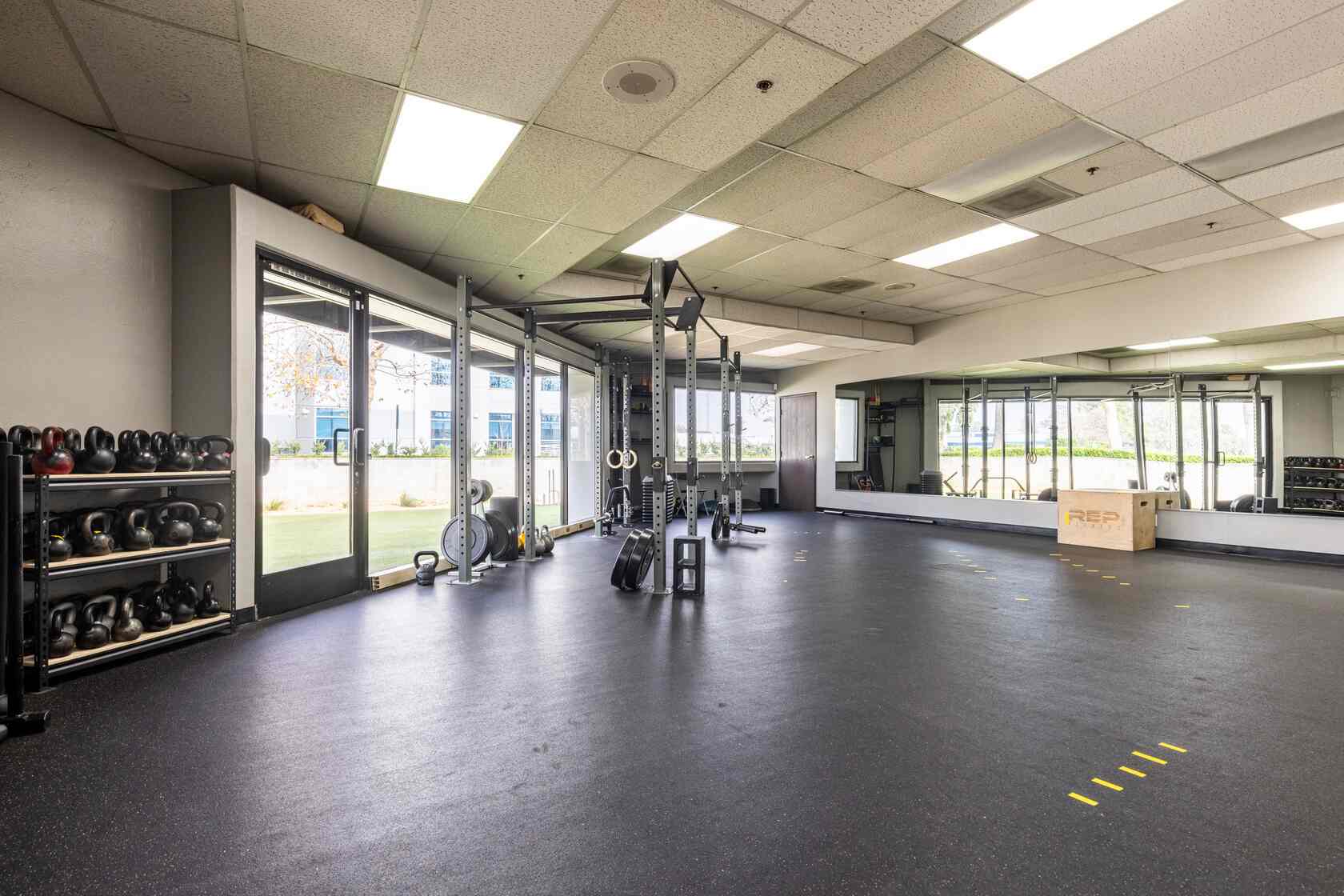 Open training floor with kettlebell wall and rig